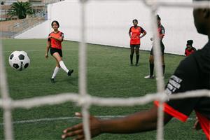 Teen Girl Kicking A Soccer Ball With The Team